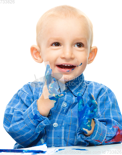 Image of Little boy is playing with paints