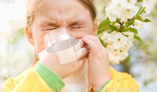 Image of Little girl is blowing her nose