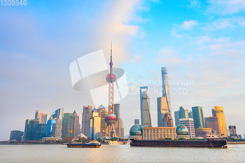 Image of Shanghai skyline, barges by waterfront