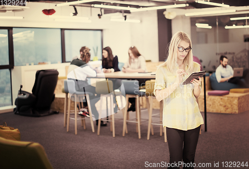 Image of blonde businesswoman working online using digital tablet