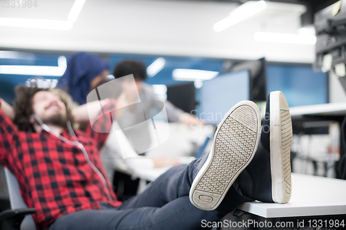 Image of software developer resting with legs on desk