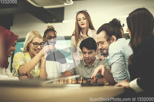 Image of multiethnic group of business people playing chess