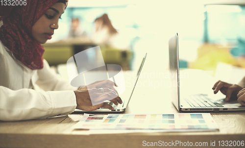 Image of black muslim business woman ,working on laptop computer