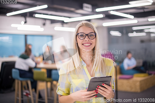 Image of blonde businesswoman working online using digital tablet