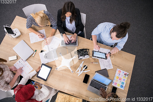 Image of top view of multiethnic business team learning about drone techn