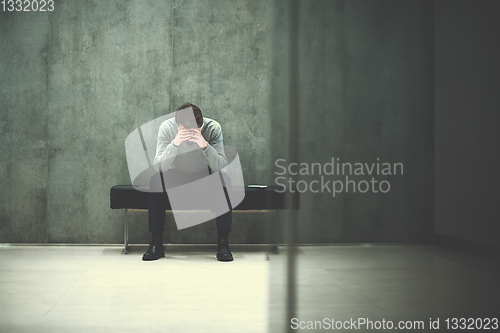 Image of businessman using smart phone while sitting on the bench