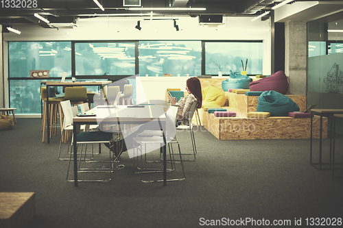 Image of redhead businesswoman using mobile phone at office