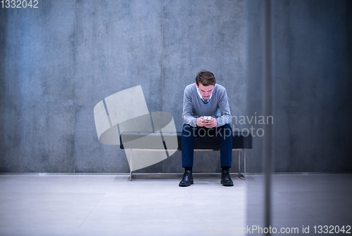 Image of businessman using smart phone while sitting on the bench