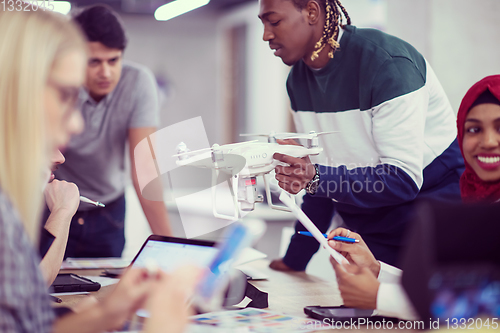 Image of multiethnic business team learning about drone technology