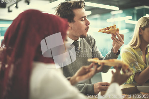 Image of multiethnic business team eating pizza