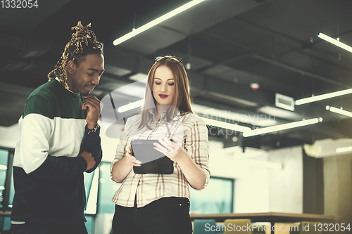Image of multiethnic business couple using a tablet computer