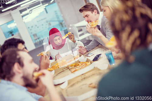 Image of multiethnic business team eating pizza