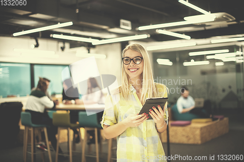 Image of blonde businesswoman working online using digital tablet