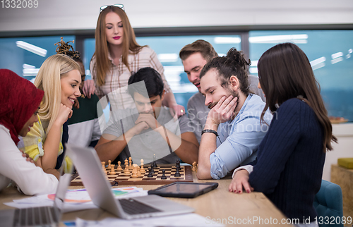 Image of multiethnic group of business people playing chess