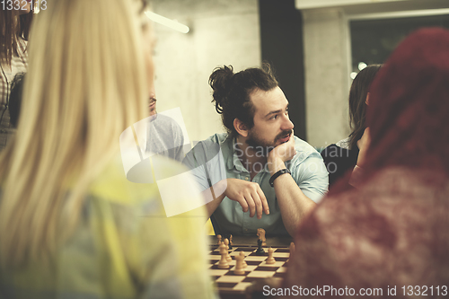 Image of multiethnic group of business people playing chess