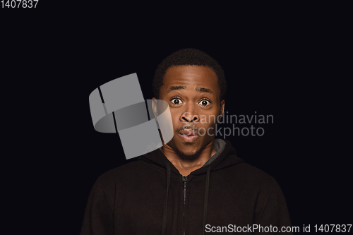 Image of Close up portrait of young man isolated on black studio background