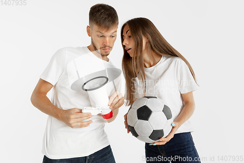 Image of Portrait of beautiful couple football fans on white studio background