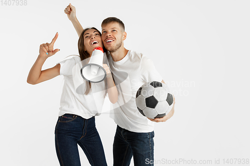 Image of Portrait of beautiful couple football fans on white studio background