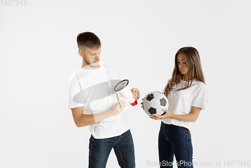 Image of Portrait of beautiful couple football fans on white studio background