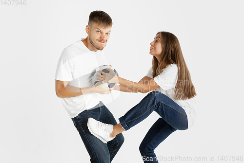 Image of Portrait of beautiful couple football fans on white studio background