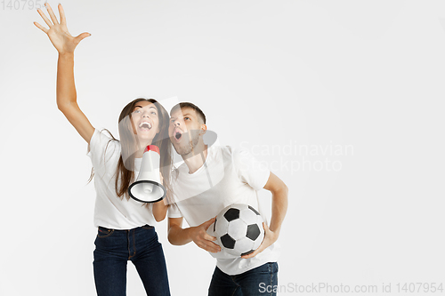 Image of Portrait of beautiful couple football fans on white studio background