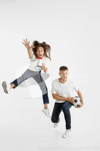 Image of Portrait of beautiful couple football fans on white studio background