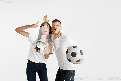 Image of Portrait of beautiful couple football fans on white studio background