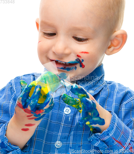 Image of Little boy is playing with paints