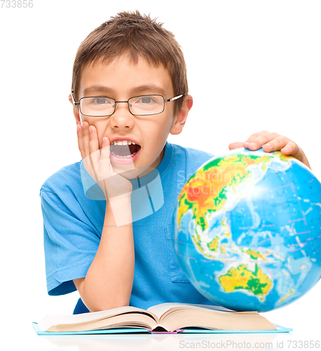 Image of Little boy is holding globe