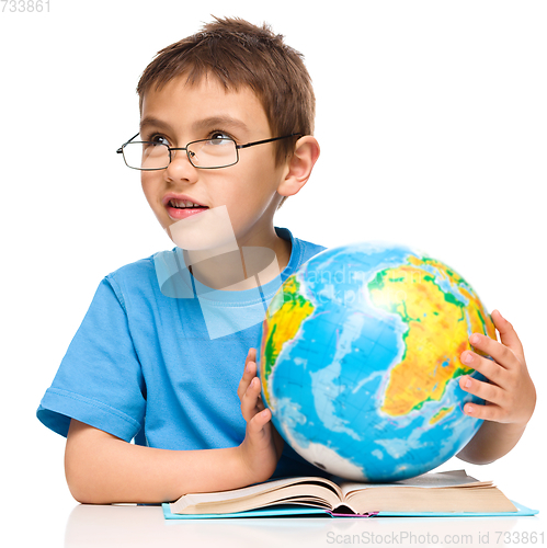 Image of Little boy is holding globe