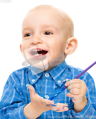 Image of Little boy is playing with paints