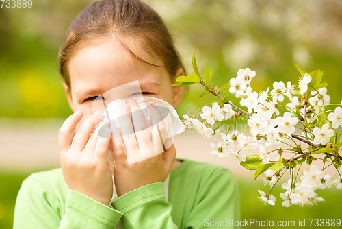 Image of Little girl is blowing her nose