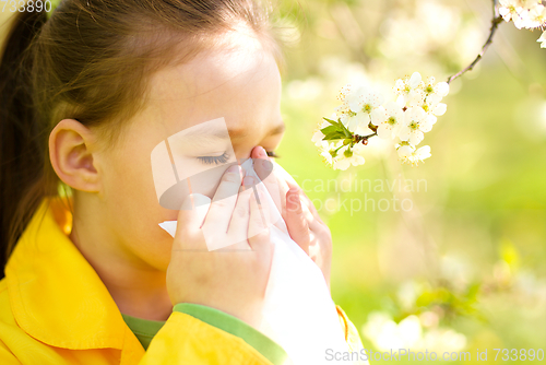 Image of Little girl is blowing her nose