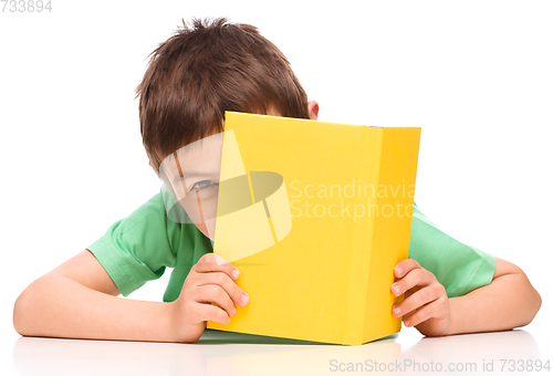 Image of Little boy plays with book