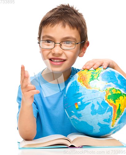 Image of Little boy is holding globe