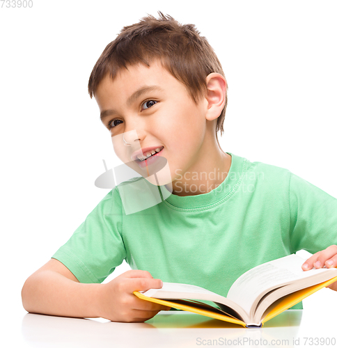 Image of Little boy plays with book