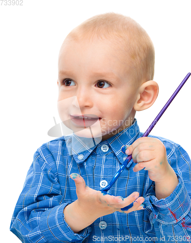 Image of Little boy is playing with paints