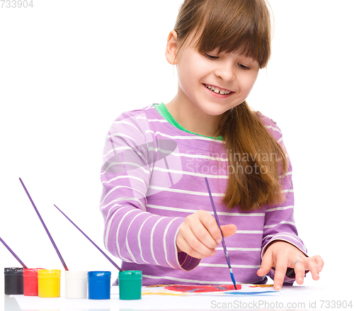 Image of Little girl is painting with gouache