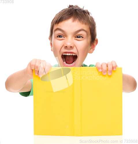 Image of Little boy is holding a book