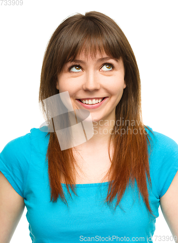 Image of Young happy woman is looking up and smile