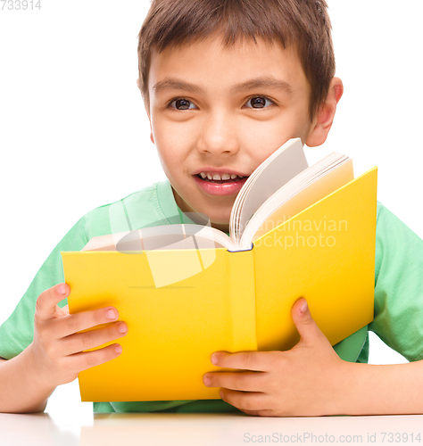 Image of Little boy plays with book