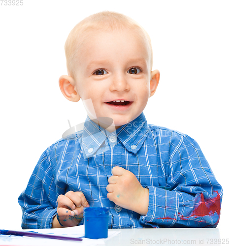 Image of Little boy is playing with paints