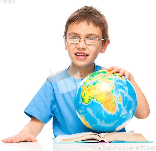 Image of Little boy is holding globe