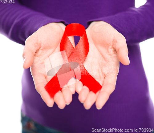 Image of Woman is holding the red awareness ribbon