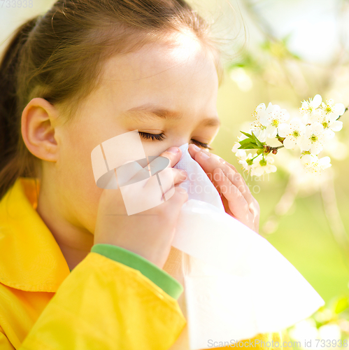 Image of Little girl is blowing her nose