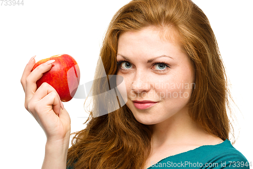 Image of Young happy girl with apple