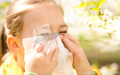 Image of Little girl is blowing her nose