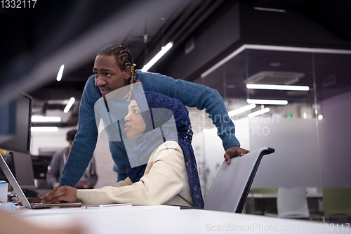 Image of young black muslim female software developer at work