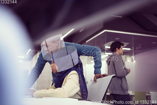Image of young black muslim female software developer at work