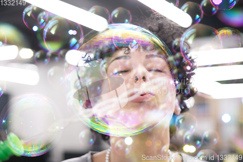 Image of software developer having fun while making soap bubble